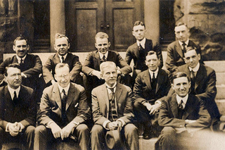 Men in black and white photo sitting on yale steps